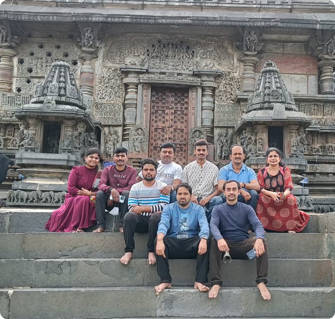 Group of people posing in front of a historic stone temple.